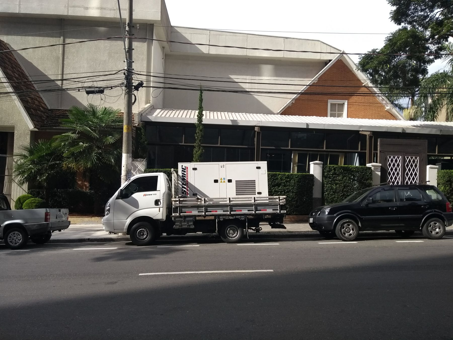 Gerador de energia sobre caminhão ao lado de edifício, pronto para a instalação