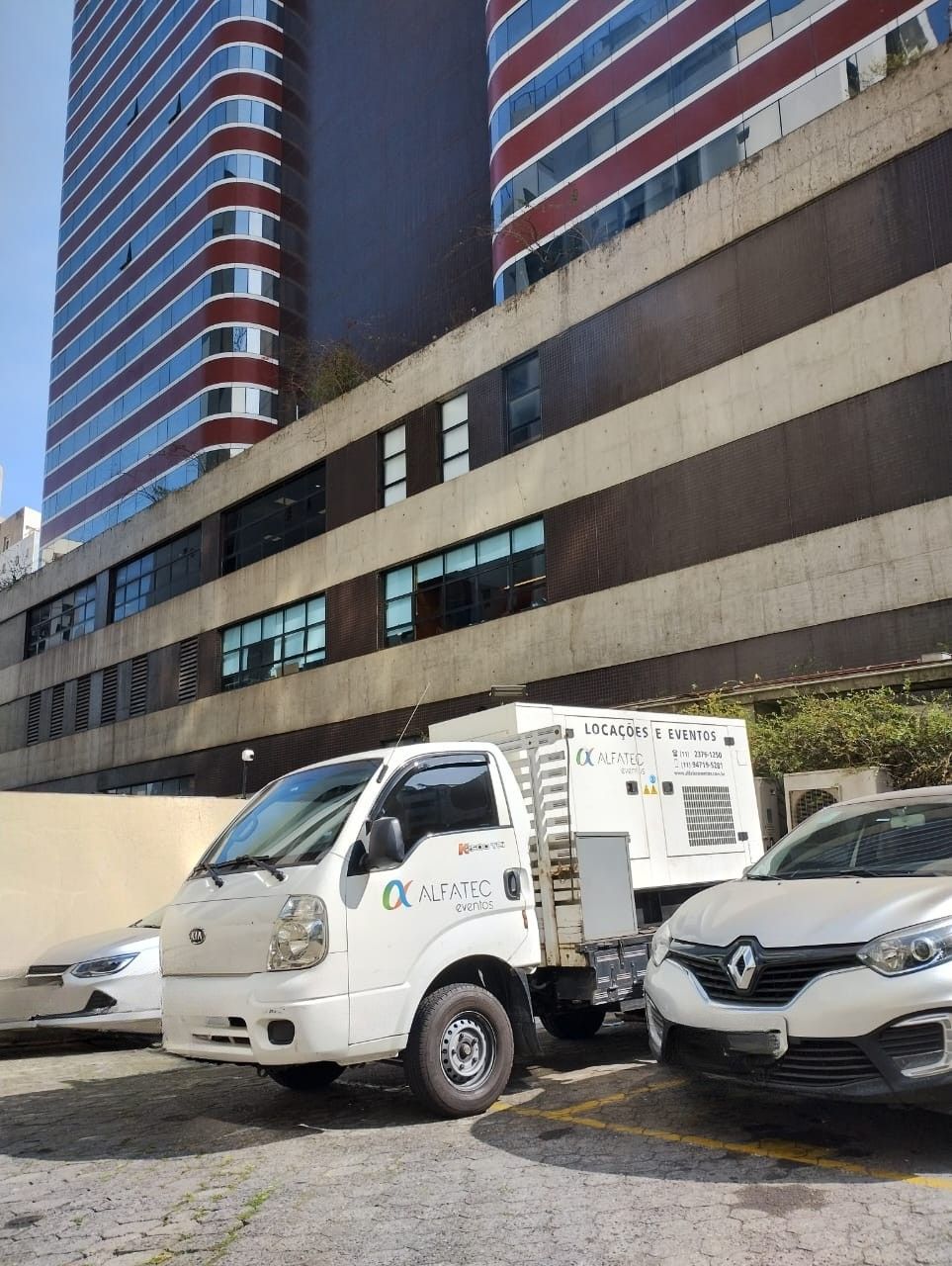 Caminhão da Alfatec com gerador estacionado em frente a prédio comercial